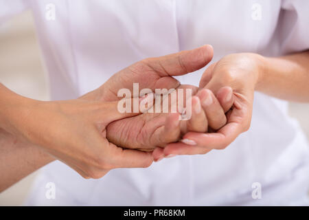 In der Nähe des Handgelenks ein Weibliches, der Arzt, der die Untersuchung des Patienten Stockfoto