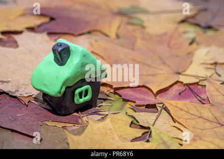 Kleines Haus aus dem Spiel Ton gemacht. Auf Herbst Hintergrund isoliert. Stockfoto