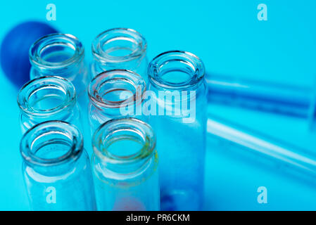 Verschmutzte Reagenzgläser auf blauem Hintergrund. Forschung im Labor. Stockfoto