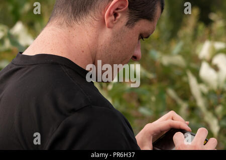 Junger Mann bilder Kontrolle auf dem Telefon Stockfoto