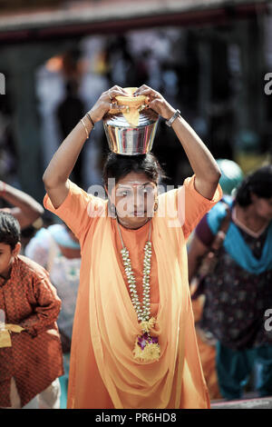 Frau hält Milch Topf auf Kopf während Thaipusam Festival am Batu Höhlen in Selangor, Malaysia Stockfoto