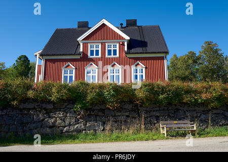 Ein traditionelles Rot lackierten Holz- Norwegische Haus auf dem Hügel mit Blick über Stockmarknes, Nordland County, Norwegen. Stockfoto