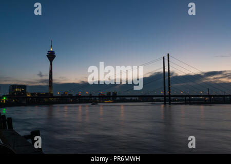 Sonnenuntergang über Düsseldorf, Deutschland, mit den Silhouetten der Rheinturm Turm und den Medienhafen. Stockfoto