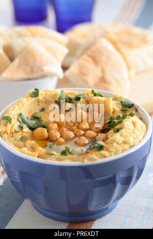 Hummus mit ganzen Kichererbsen, Petersilie und Olivenöl Stockfoto