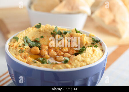 Hummus mit ganzen Kichererbsen, Petersilie und Olivenöl Stockfoto