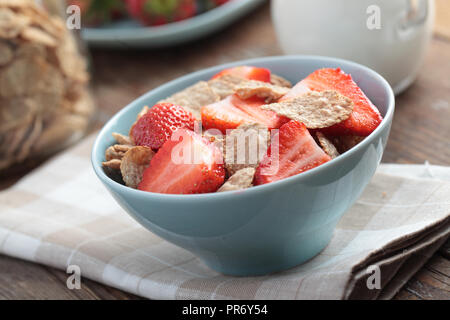 Frühstück mit Roggen- flocken und Erdbeere in eine blaue Schale Stockfoto