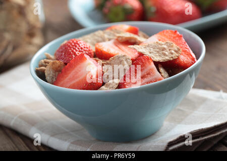 Frühstück mit Roggen- flocken und Erdbeere in eine blaue Schale Stockfoto