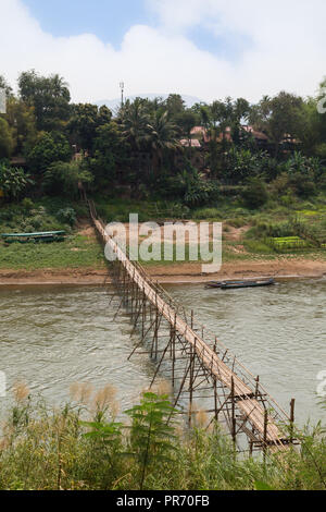 Ansicht eines Bambus Brücke über den Fluss Nam Khan und üppigen Ufer in Luang Prabang, Laos, an einem sonnigen Tag. Stockfoto