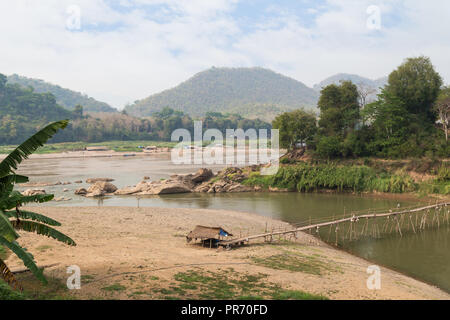 Blick auf den Mekong Fluss, ein Bambus Brücke über den Fluss Nam Khan bei Ebbe und üppigen Ufer in Luang Prabang, Laos, an einem sonnigen Tag. Stockfoto