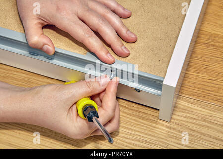 Verwendung von Möbeln Verbindungselemente bei der Montage einer Schublade, Hände eines Möbel builder Close-up. Stockfoto