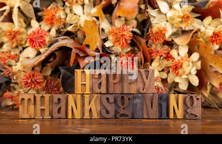 Happy Thanksgiving Text mit Holzblock Buchstaben auf einem bunten Herbst farbigen Hintergrund geschrieben Stockfoto