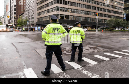 New York City Polizisten den Verkehr an der Kreuzung der Park Avenue und West 57th Street an einem regnerischen Morgen. Stockfoto