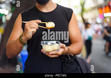 Mann baozi Essen auf der Straße in China. Stockfoto