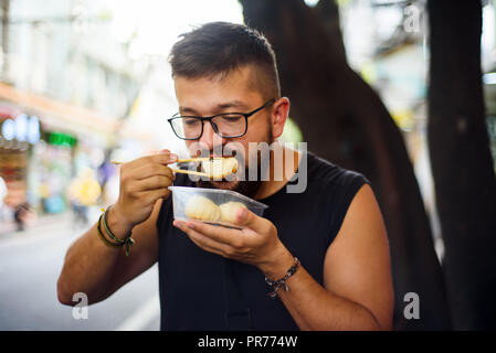 Ausländer baozi Essen auf der Straße in China. Stockfoto