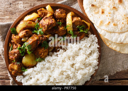 Scharfe indische Huhn tun Pyaaza mit Zwiebeln mit Garnierung von Reis in der Nähe serviert auf einem Teller auf dem Tisch. horizontal oben Ansicht von oben Stockfoto