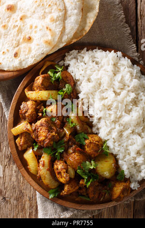 Scharfe indische Huhn tun Pyaaza mit Zwiebeln mit Garnierung von Reis in der Nähe serviert auf einem Teller auf dem Tisch. Vertikal oben Ansicht von oben Stockfoto