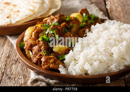 Köstliche indische Punjabi Huhn dopiaza mit Zwiebeln mit Beilage von Reis in der Nähe serviert auf einem Teller auf den Tisch. Horizontale Stockfoto