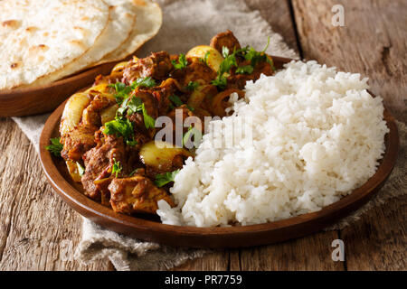 Spicy Chicken do pyaza Curry, die doppelte Menge der Zwiebeln mit garnieren Reis close-up auf einem Teller auf dem Tisch. Horizontale Stockfoto