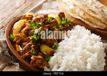 Scharfe indische Huhn tun Pyaaza mit Zwiebeln mit Garnierung von Reis in der Nähe serviert auf einem Teller auf dem Tisch. Horizontale Stockfoto