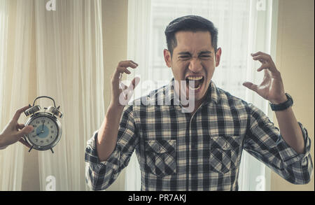 Casual Male ist schreiend aus Wecker betonte Stockfoto