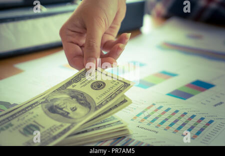 Business woman Hand aufnehmen Geld aus Geschäft Schreibtisch Stockfoto