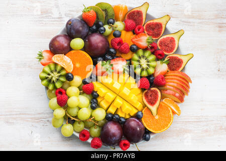 Gesunde rohe Früchte und Beeren, Orangen, Pflaumen Erdbeeren Himbeeren Äpfel, Kiwis, Weintrauben, Heidelbeeren, Mango auf dem weißen woorden Tabelle Stockfoto