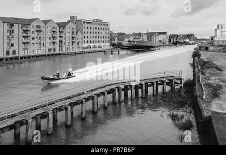 Humber Rescue aufblasbare Geschwindigkeiten down River Hull durch moderne Wohnungen und Büros und baufälligen Causeway, Hull, Yorkshire, UK flankiert. Stockfoto