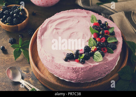 Kuchen mit Schwarze Johannisbeere Creme Souffle und Keks auf einem Tisch im rustikalen Stil. Getönten Bild. Stockfoto
