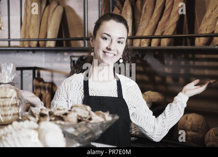 Weibliches Personal verkaufen frisches Gebäck und Baguettes in der örtlichen Bäckerei Stockfoto