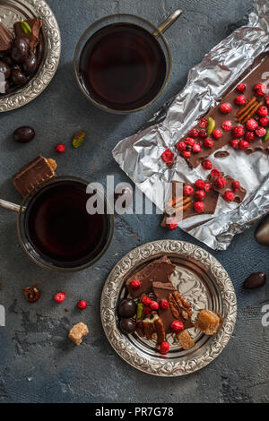 Tassen Kaffee mit Schokolade auf einem Stein. Stockfoto