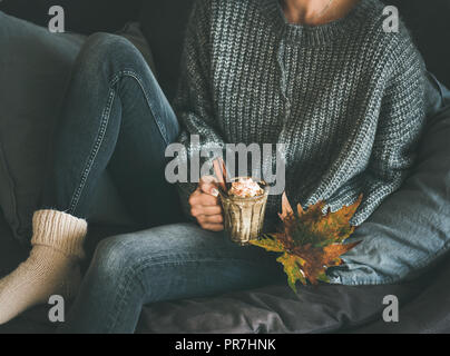 Frau in Wollpullover holding Becher mit heißer Schokolade Stockfoto