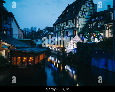 Blick von einer Brücke in Straßburg, Frankreich, in der Nacht mit verschiedenen schönen Lichter und Windows über einen Fluss mit Booten. Weihnachten Stockfoto
