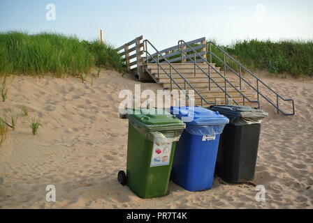 Recycling, Abfall und organics Abfalltonnen in drei Farben grün, blau und schwarz auf einem roten Sandstrand, enrance, Greenwich Nationalpark, PEI. Kanada Stockfoto