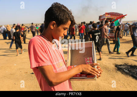 September 28, 2018 - Palästinensische Hausierer verkaufen Lebensmittel bei Auseinandersetzungen zwischen der israelischen Armee und palästinensischen Demonstration für die Große März zurück Rallye entlang der Gazastreifen Grenze im Osten von Gaza Stadt, am Freitag, den 28. September 2018. Die straßenverkäufer, von denen viele Kinder und Jugendliche, zu dem Protest essen und trinken Artikel für die palästinensische Demonstranten, die Stunden unter der sengenden Sonne verbringt. Fliegende Händler verkaufen ihre Produkte während der Auseinandersetzungen im Widerspruch zu den Gefahren der Verletzung und Tod, die Sie durch die Teilnahme an der Demonstration. Laut einer aktuellen Studie der Weltbank, Th Stockfoto