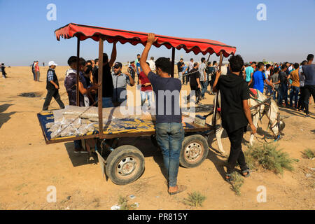 September 28, 2018 - Palästinensische Hausierer verkaufen Lebensmittel bei Auseinandersetzungen zwischen der israelischen Armee und palästinensischen Demonstration für die Große März zurück Rallye entlang der Gazastreifen Grenze im Osten von Gaza Stadt, am Freitag, den 28. September 2018. Die straßenverkäufer, von denen viele Kinder und Jugendliche, zu dem Protest essen und trinken Artikel für die palästinensische Demonstranten, die Stunden unter der sengenden Sonne verbringt. Fliegende Händler verkaufen ihre Produkte während der Auseinandersetzungen im Widerspruch zu den Gefahren der Verletzung und Tod, die Sie durch die Teilnahme an der Demonstration. Laut einer aktuellen Studie der Weltbank, Th Stockfoto