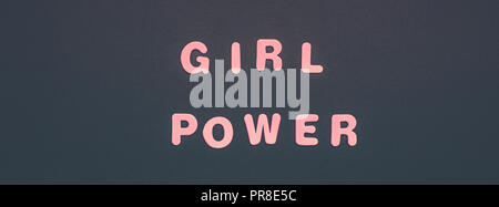 Kreative pink Text aus Kunststoff Buchstaben GIRL POWER Schrift auf schwarzem Papier Hintergrund mit Kopie Raum gemacht. Frauen empowerment Konzept, Vorlage für FEM Stockfoto