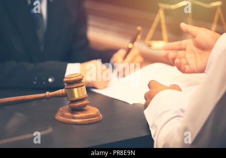 Anwalt reden und Entscheidung, dem Rechtsberater präsentiert auf dem Client einen unterzeichneten Vertrag mit Richter Hammer auf hölzernen Schreibtisch. Justiz und Rechtsanwalt Konzept Stockfoto