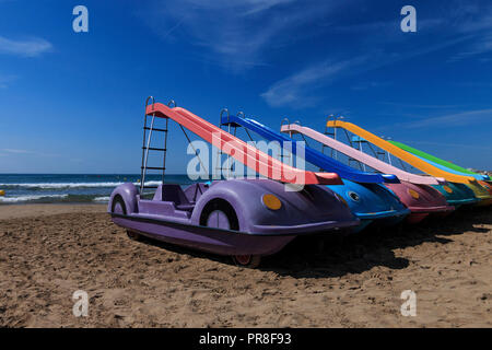 Tretboote mit shute sind bis auf einen Strand und Wasser Hintergrund gefüttert Stockfoto