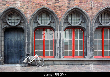 Lonely Fahrrad stehend gegen die Wand der alten historischen Gebäude in Brügge, Belgien. Stockfoto