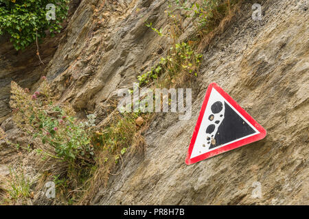 Küstenlandschaft um Newquay, Cornwall. Achten Sie auf das Warnschild „Falling Rocks“ an den Klippen von Newquay. Stockfoto