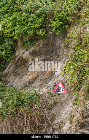 Küstenlandschaft um Newquay, Cornwall. Achten Sie auf das Warnschild „Falling Rocks“ an den Klippen von Newquay. Stockfoto