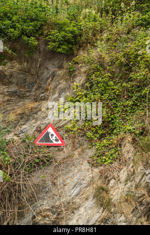 Küstenlandschaft um Newquay, Cornwall. Achten Sie auf das Warnschild „Falling Rocks“ an den Klippen von Newquay. Stockfoto