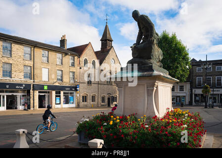 War Memorial de Stadt aus, Blick eines Kindes radfahren Vergangenheit ein Kriegerdenkmal in Bury St Edmunds Marktplatz, Suffolk, East Anglia, Großbritannien. Stockfoto