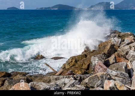 Die Wellen des Meeres brechen auf den Felsen von Tellaro, mit dem Golf von La Spezia, Ligurien, Italien Stockfoto