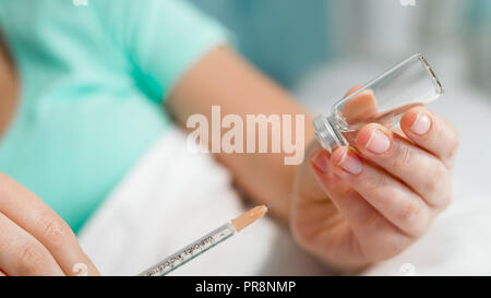 Nahaufnahme der weiblichen Arzt holding Ampulle mit Medikamenten und Spritze Stockfoto