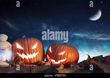 Zwei Halloween Kürbisse auf Zaun mit Sternenhimmel im Hintergrund. Horizontale Ausrichtung Stockfoto