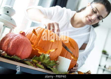 Junge Frau bereitet Kürbisse als Deko für Halloween Stockfoto