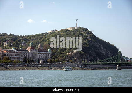 Gellért Berg und die Freiheitsstatue, mit dem Hotel Gellért und der Freiheitsbrücke (Szabadság híd) in Budapest. Stockfoto