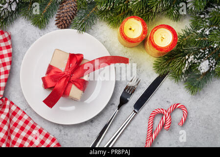 Weihnachten Tisch mit Kerzen, Zuckerstangen, Geschenkbox und Fir Tree Branch von Schnee auf Holz- Hintergrund. Ansicht von oben Stockfoto