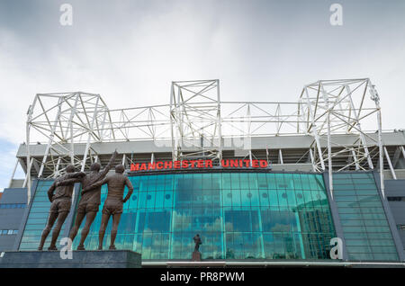 Die 'Heilige Dreifaltigkeit' Statue zum Gedenken an Dennis Law, Sir Bobby Charlton und George Best an der vorderen Fassade im Old Trafford, Manchester Stockfoto